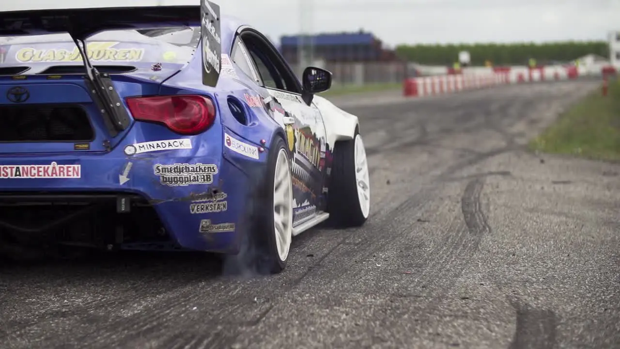 Toyota GT86 starts a drift race with extreme acceleration spinning tires and smoke from the wheels in super slow-motion