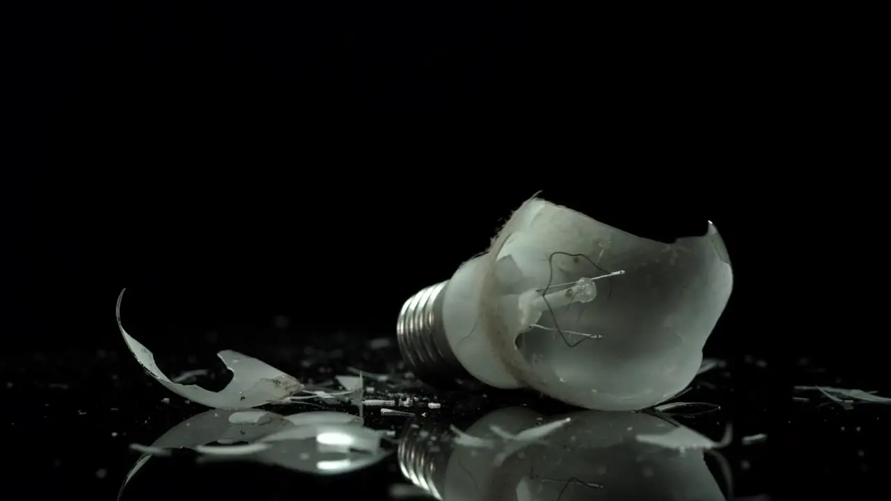 Incandescent lamp light bulb broken on small pieces of glass energy solving concept