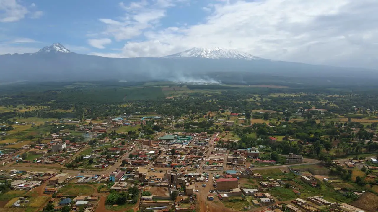 Grasslands burning accident near a town in the Eastern Africa Aerial reverse drone shot