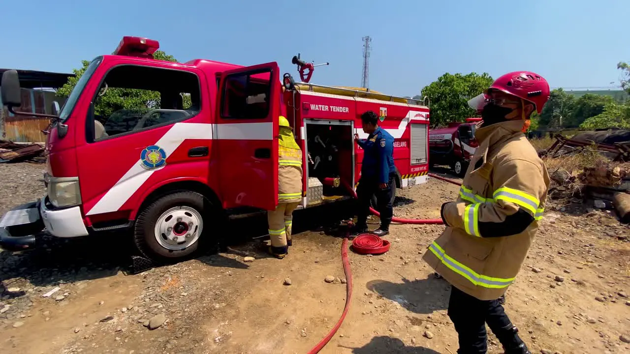 Firefighters of Indonesia preparing hose at accident location slow motion view