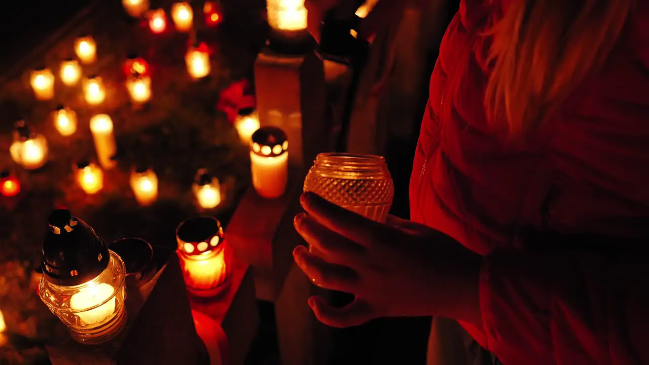 Graveyard candles are lit on the grave at night