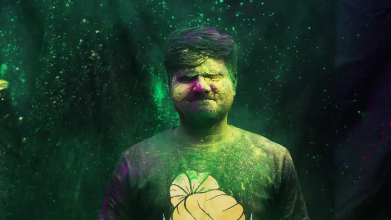 Young adult man celebrating holi with colors