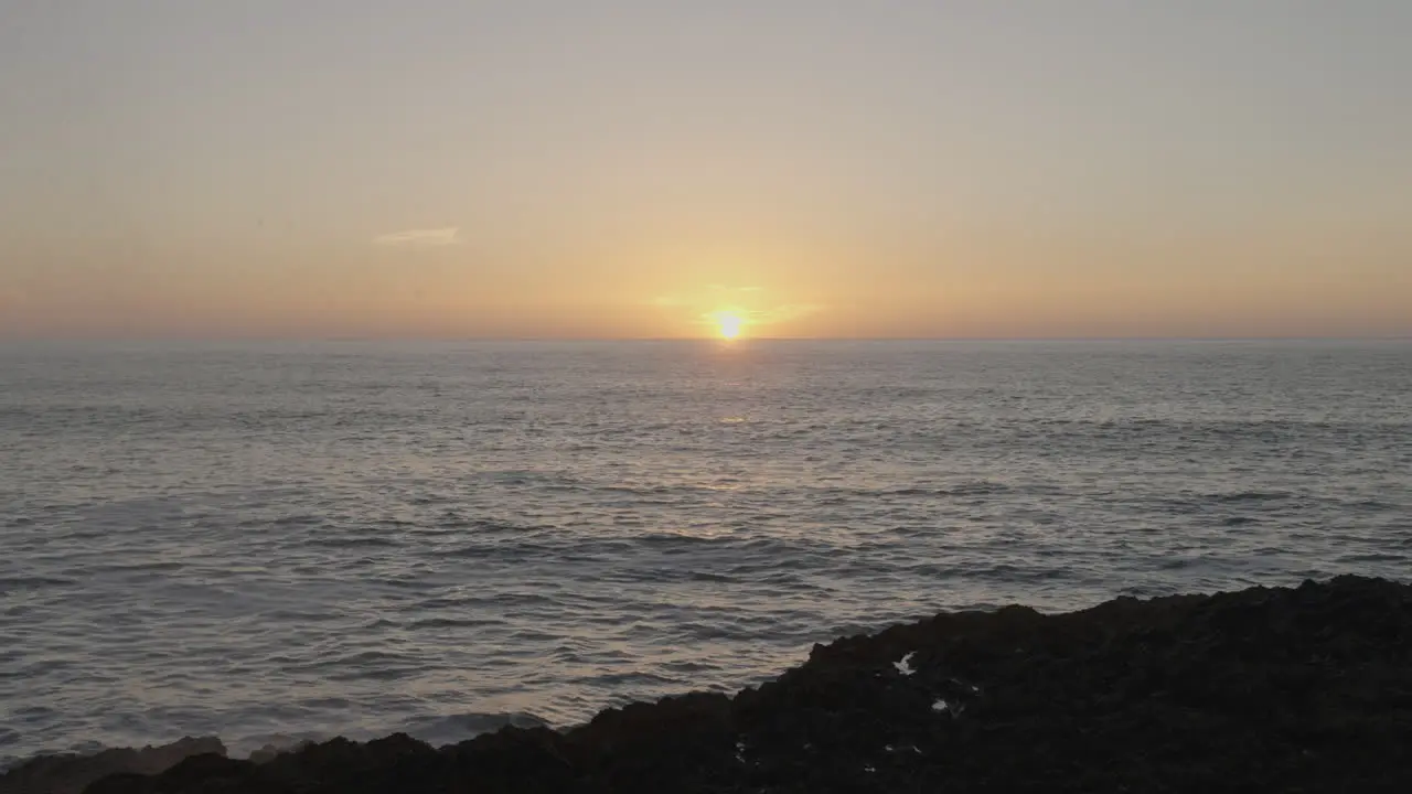 Waves hitting the rocks creating a water splash during the sunset in Ericeira Portugal