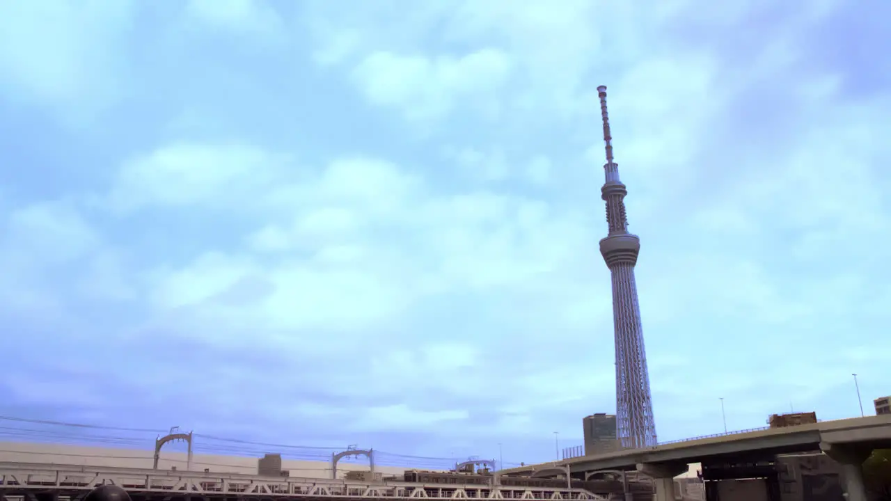 TOKYO SKYTREE ASAKUSA TOKYO JAPAN circa April 2020 trucks and cars running on a bridge crosses over the tracks train runs slowly