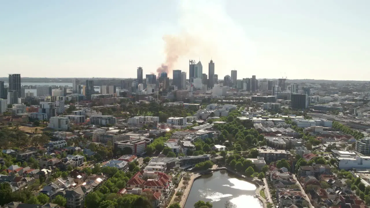 Tracking aerial shot of Perth CBD with smoke in the background from a fire