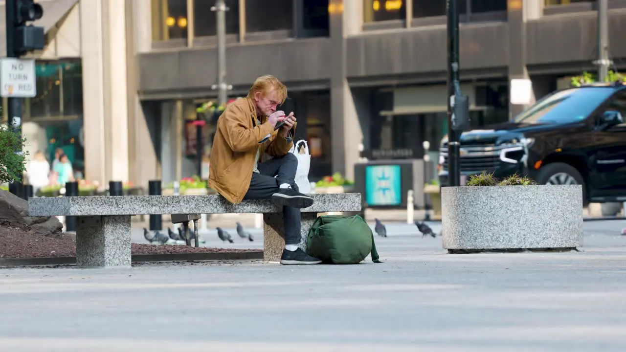 soft focused image of a man in the background using his phone while commuters are walking past the scene