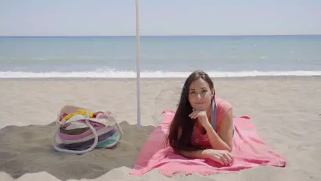 Cute woman laying down on beach blanket