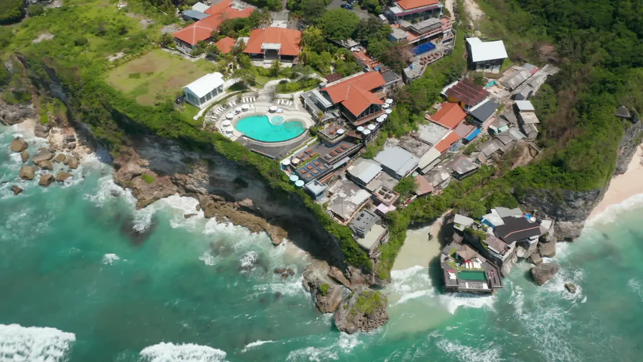 Aerial view of luxury tropical resort and villas with pool on the cliff above turquoise blue sea in Bali Indonesia