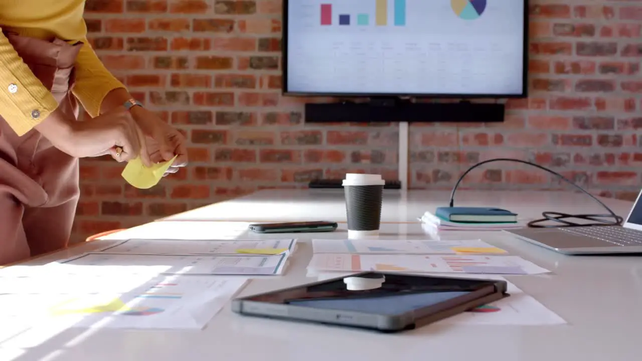 Midsection of african american casual businesswoman looking at documents in office slow motion