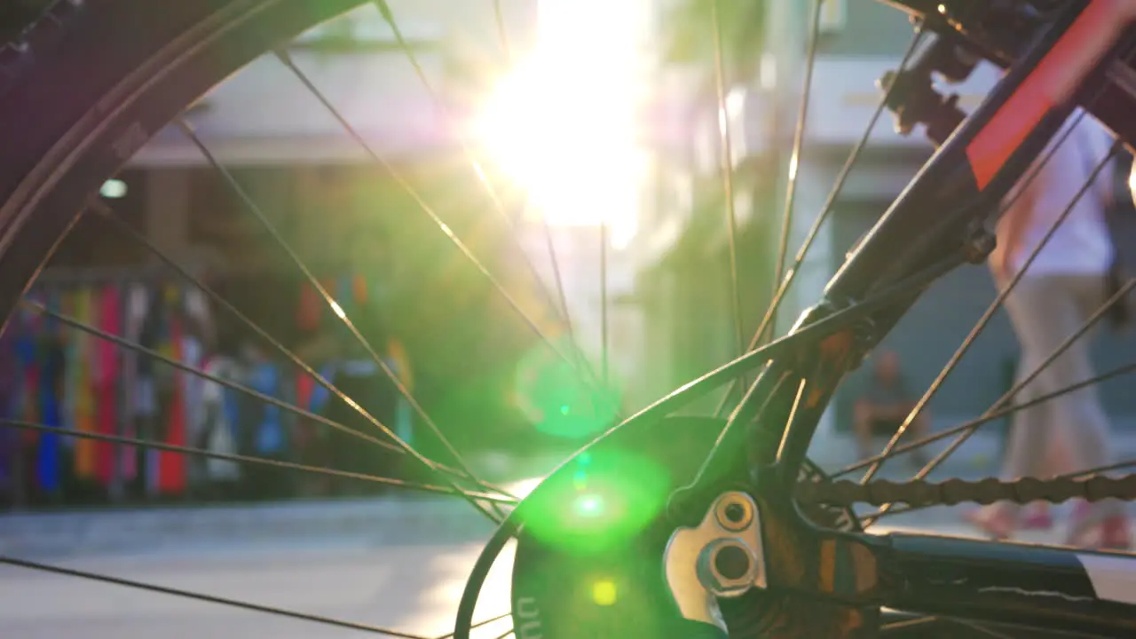 Street and sun flare view through bike wheel