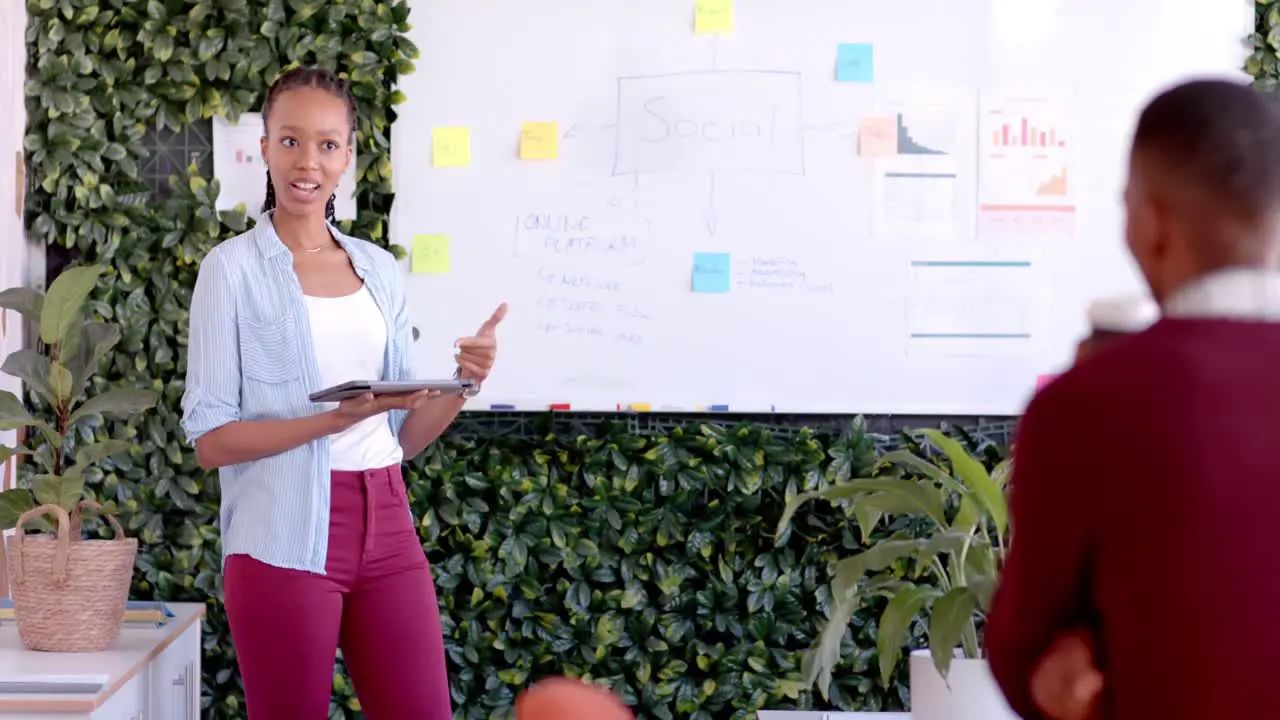 African american casual businesswoman making presentation at whiteboard in office slow motion