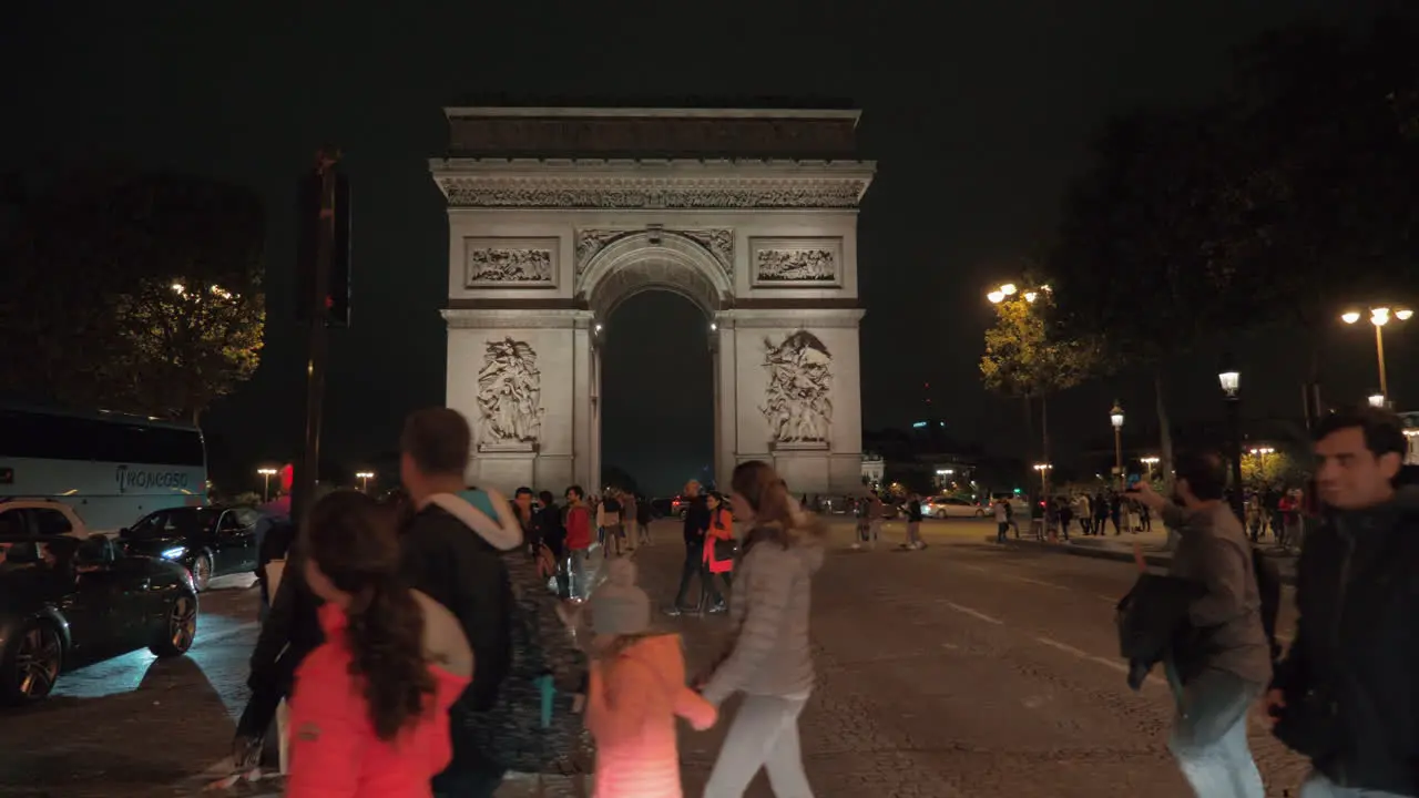 City view with Arc de Triomphe in night Paris People crossing the road