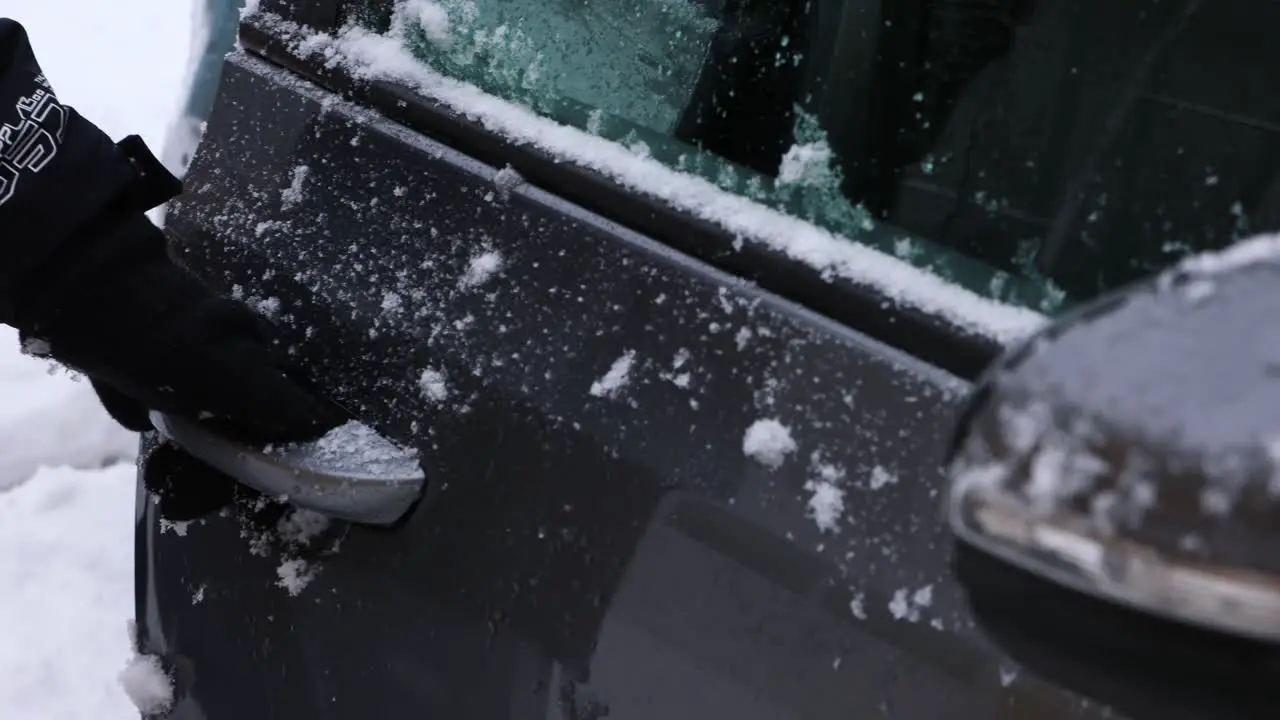 A Person With Gloves Is Opening The Car Door With Fresh Snow