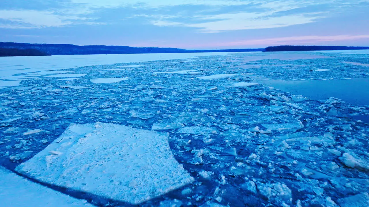 Aerial video capturing the expanse of colossal ice formations drifting in the water