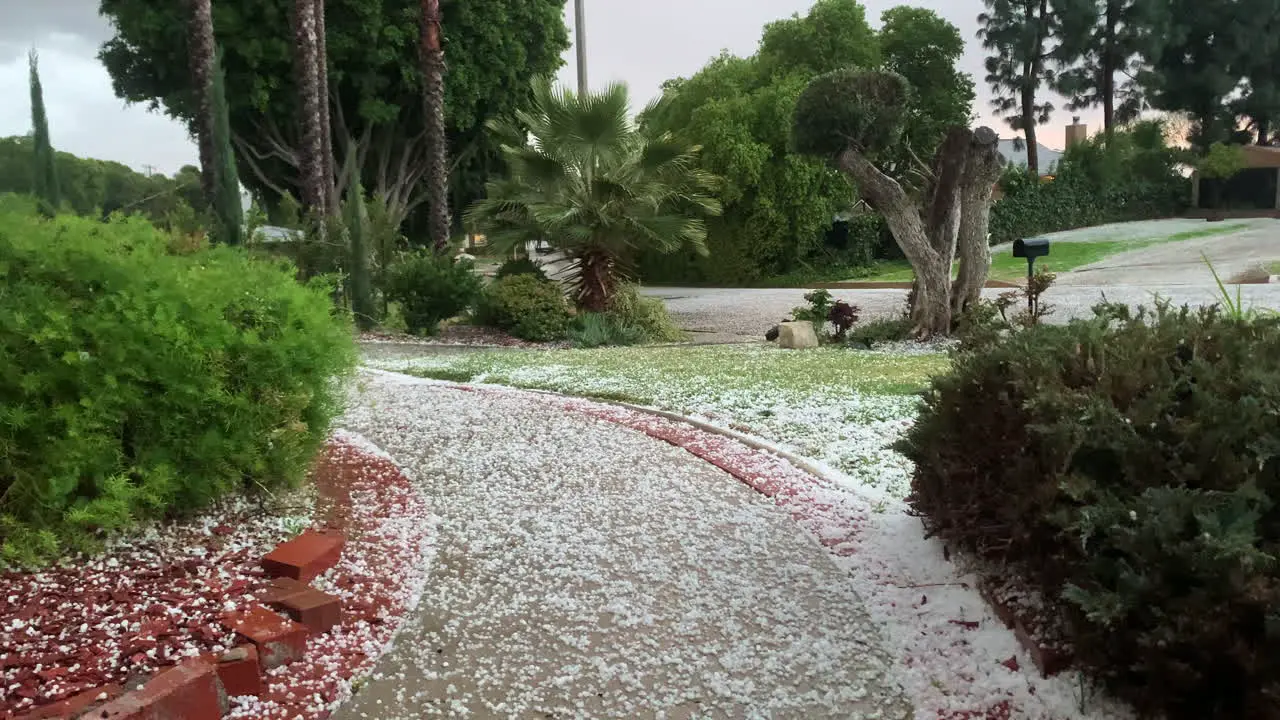 hail storm heavy rain ice stone covered garden road in California usa extreme weather condition climate change