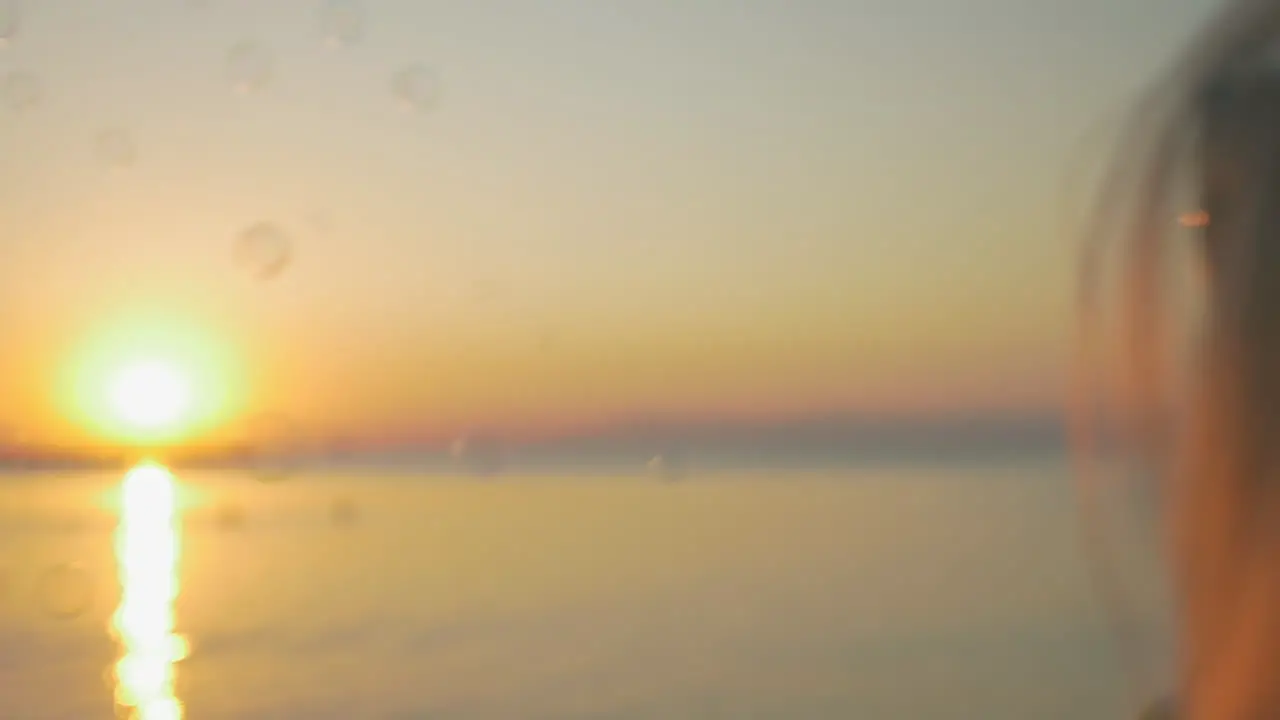 Girl blowing bubbles at sunset