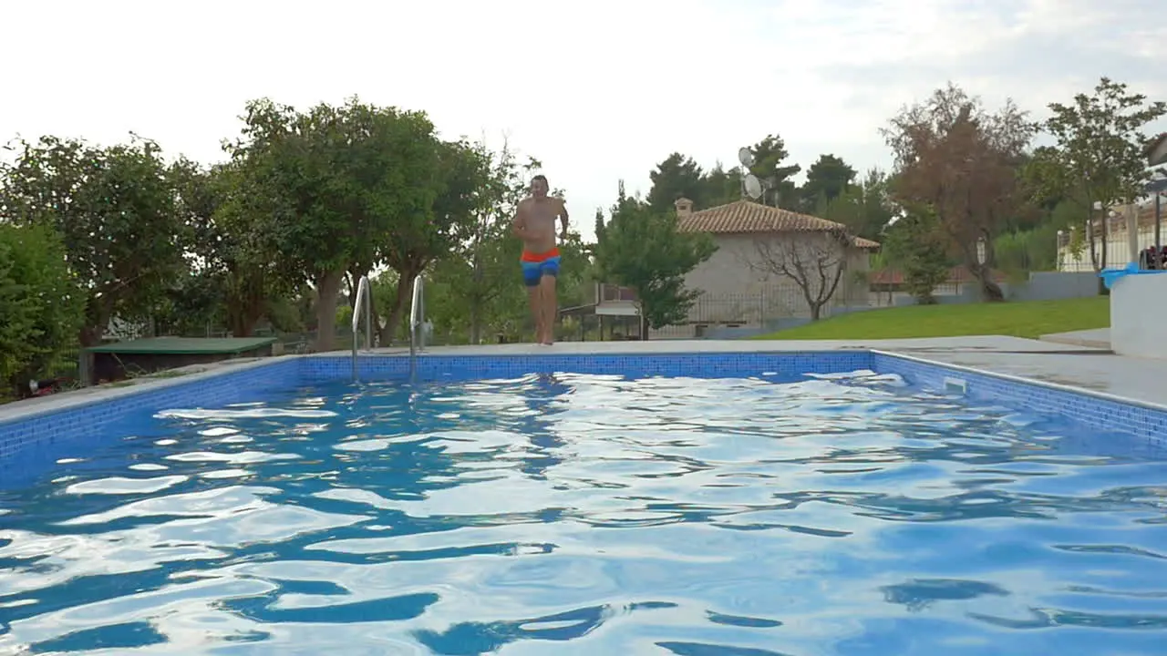 Man from a running starts jumping into the pool