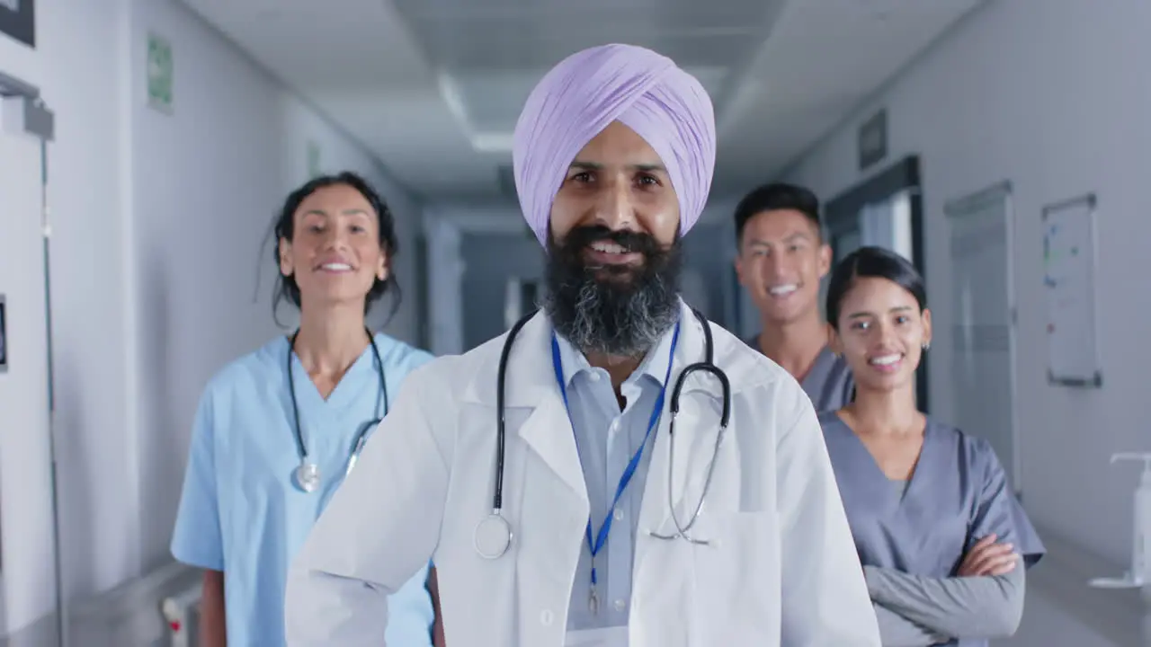 Portrait of diverse doctors and nurses smiling in corridor at hospital in slow motion