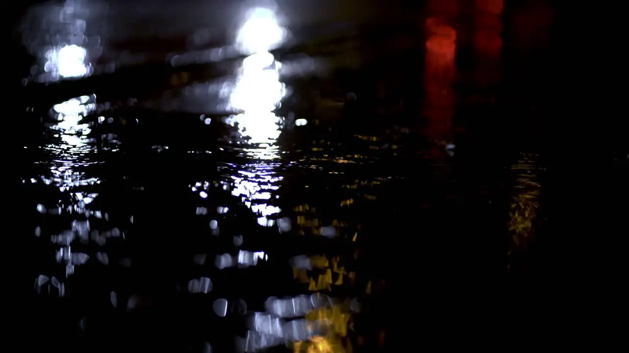 Blue lights of emergency vehicle reflecting from wet ground during rainstorm in Munich