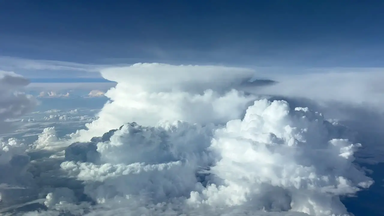 Unique view from a jet cockpit at cruise level of two huge cumulominmus ahead