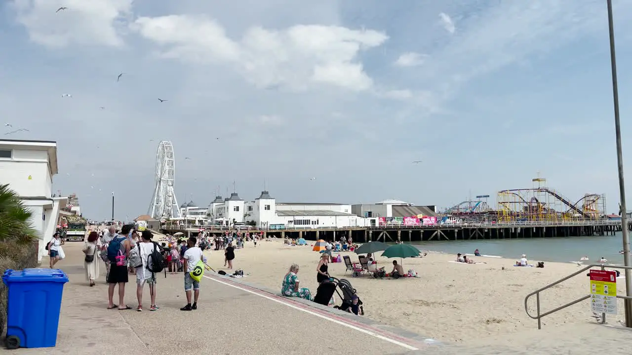 People walk along the sea front towards the pier in Clacton on Sea Essex UK