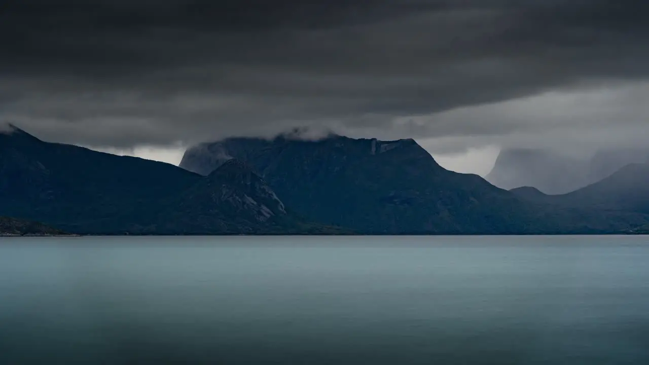 Heavy rainy clouds passing above the fjord