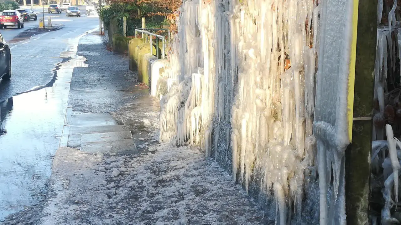 Unique frozen icicles formation on British bus stop public road hedge during bad winter weather