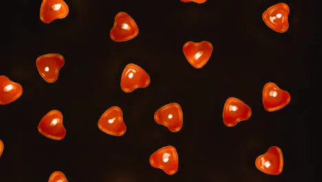 Overhead Shot Of Romantic Lit Heart Shaped Red Candles Revolving On Black Background 1