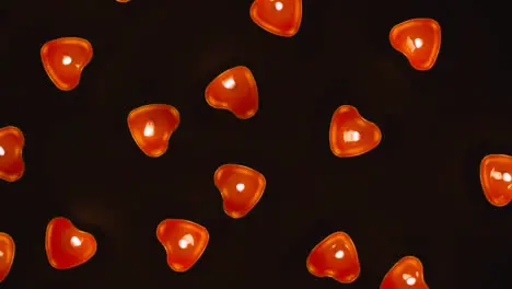 Overhead Shot Of Romantic Lit Heart Shaped Red Candles Revolving On Black Background