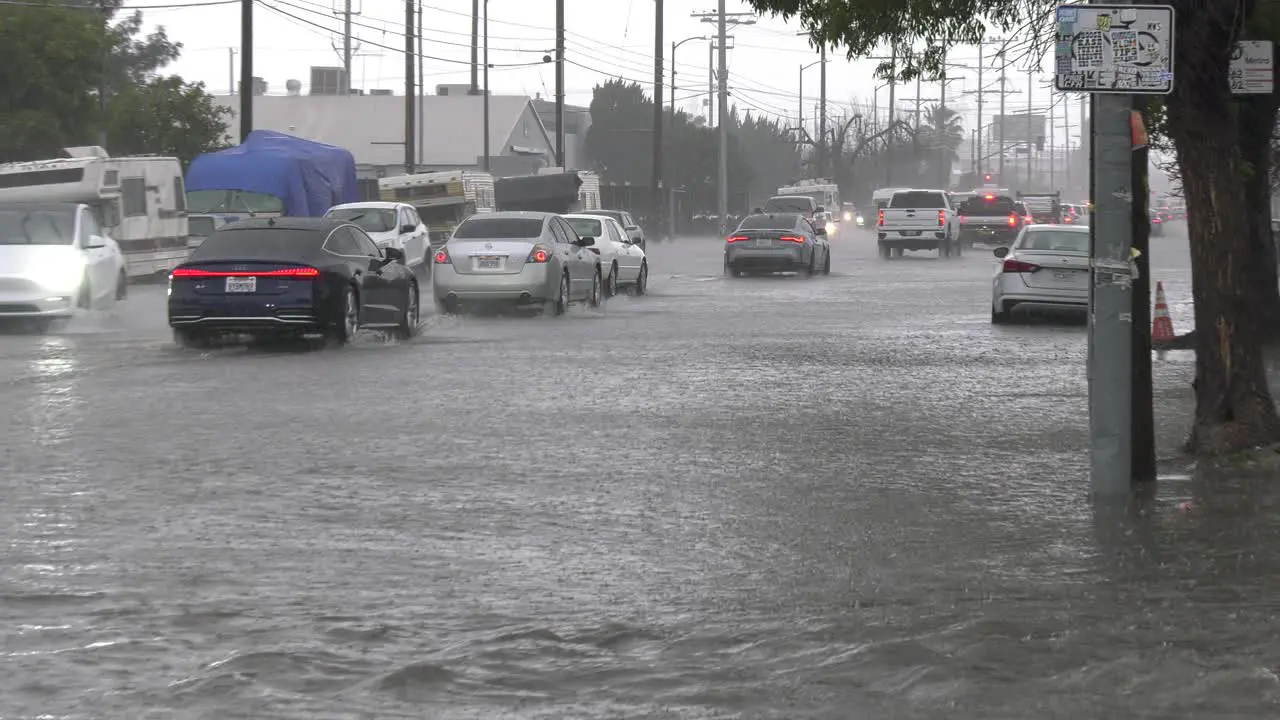 cars try to drive on flooded roads