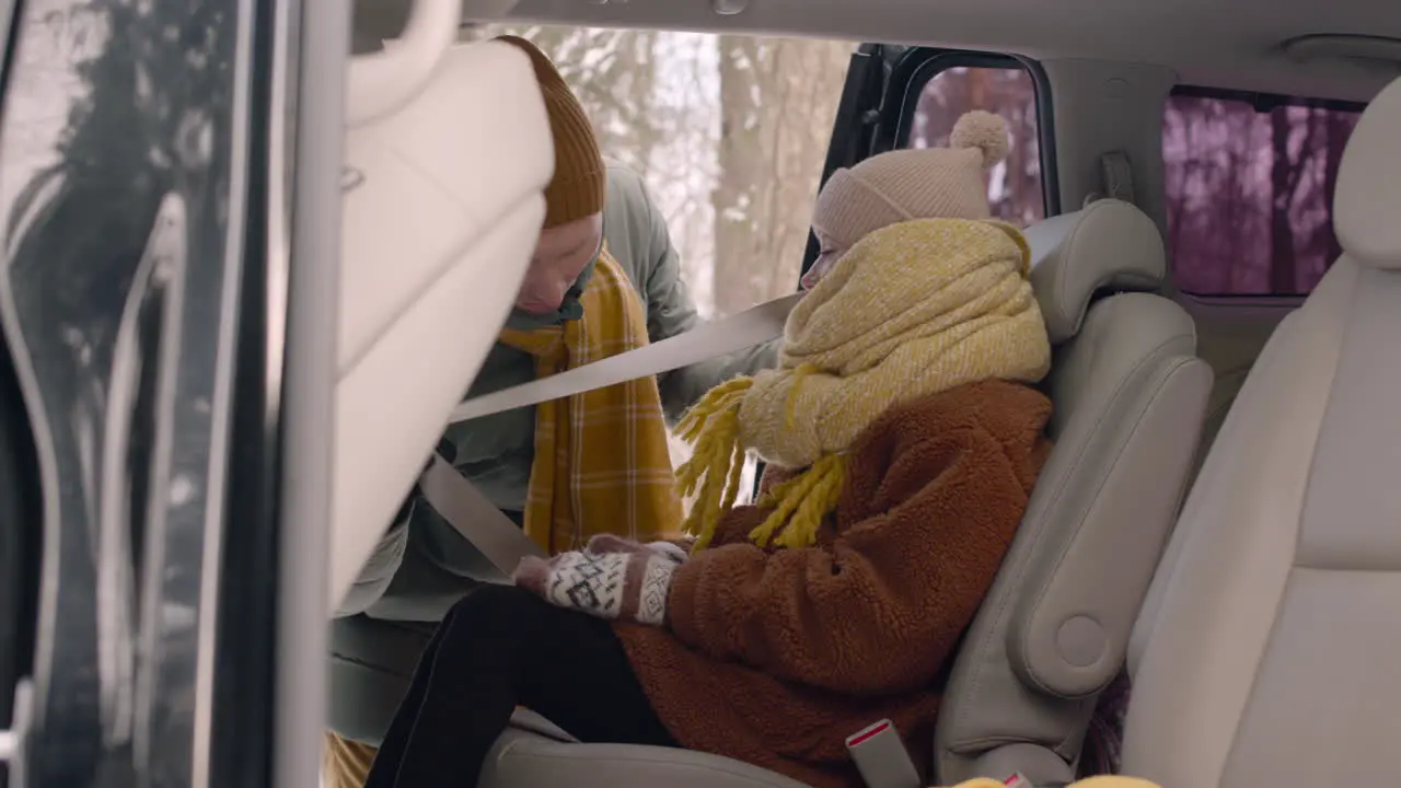 Side View Of A Girl Sitting In The Back Seat Of A Car