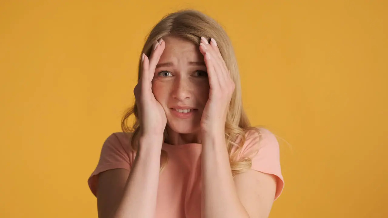 Scared Caucasian woman covering face on camera