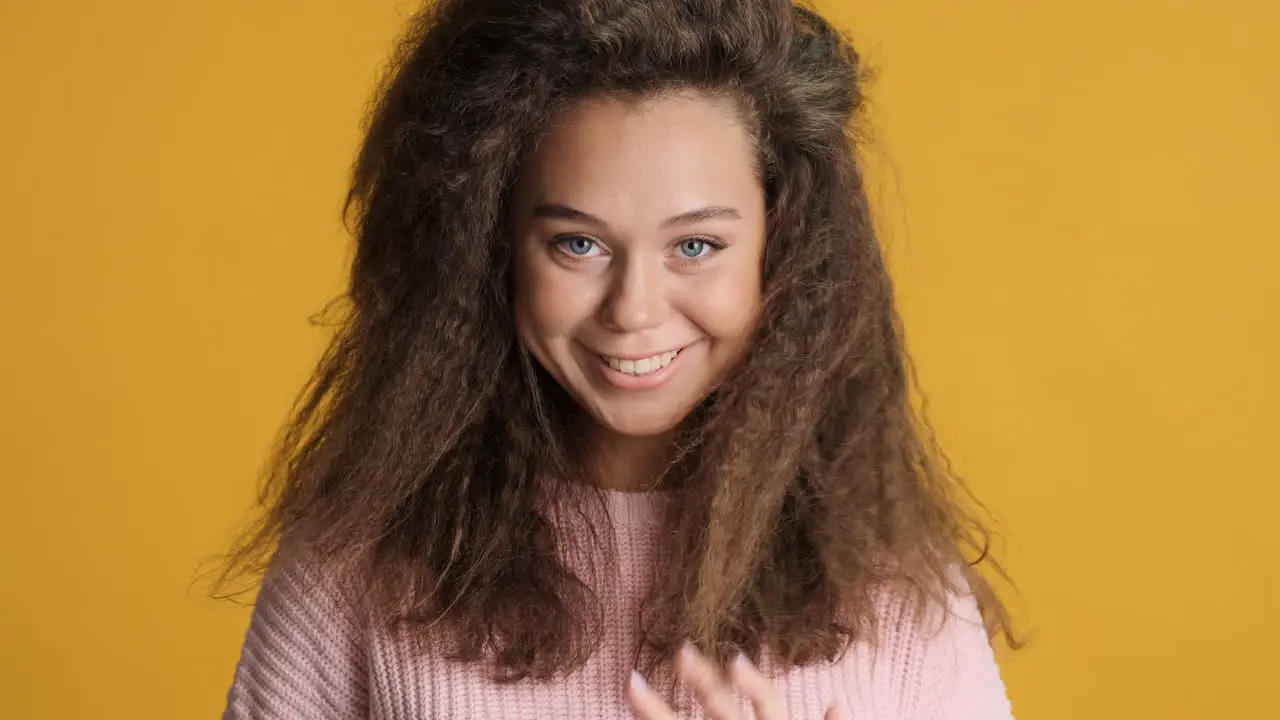 Caucasian curly haired woman smiling to the camera