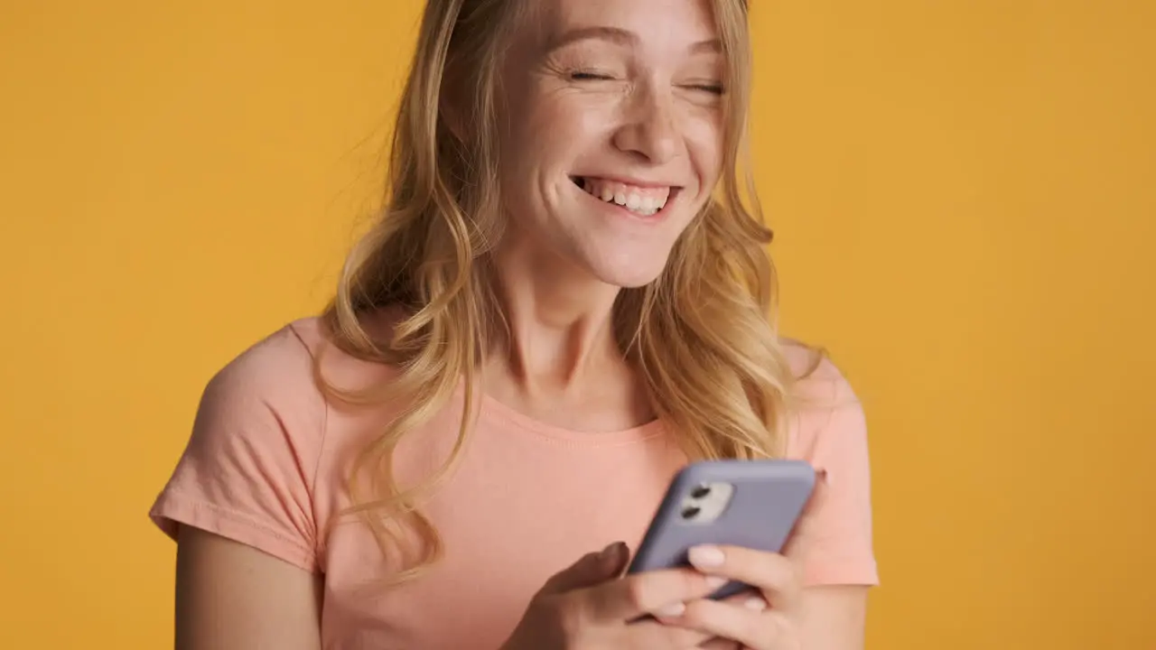 Caucasian woman using smartphone and getting excited