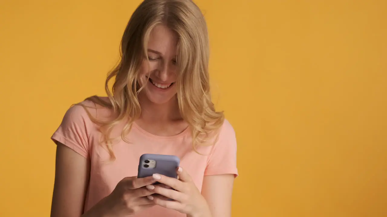 Caucasian woman using smartphone and getting surprised on camera