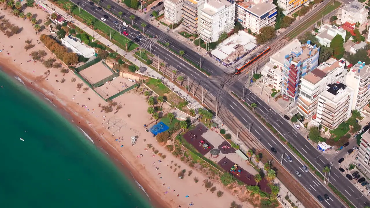 Aerial shot of a tram crossing the road to the seafront athens