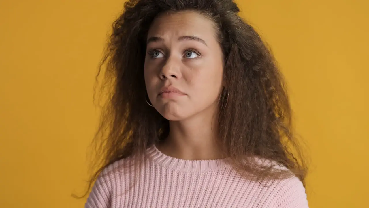 Nervous Caucasian curly haired woman in front of the camera