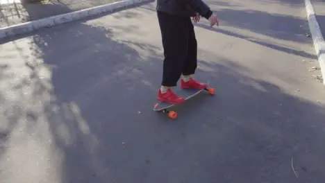 young man rides at his longboard in the city