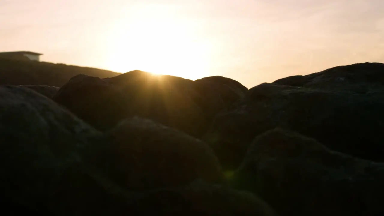 Sunset lens flares on Rocks Edge at the beach during epic Dramatic scenery light Geological