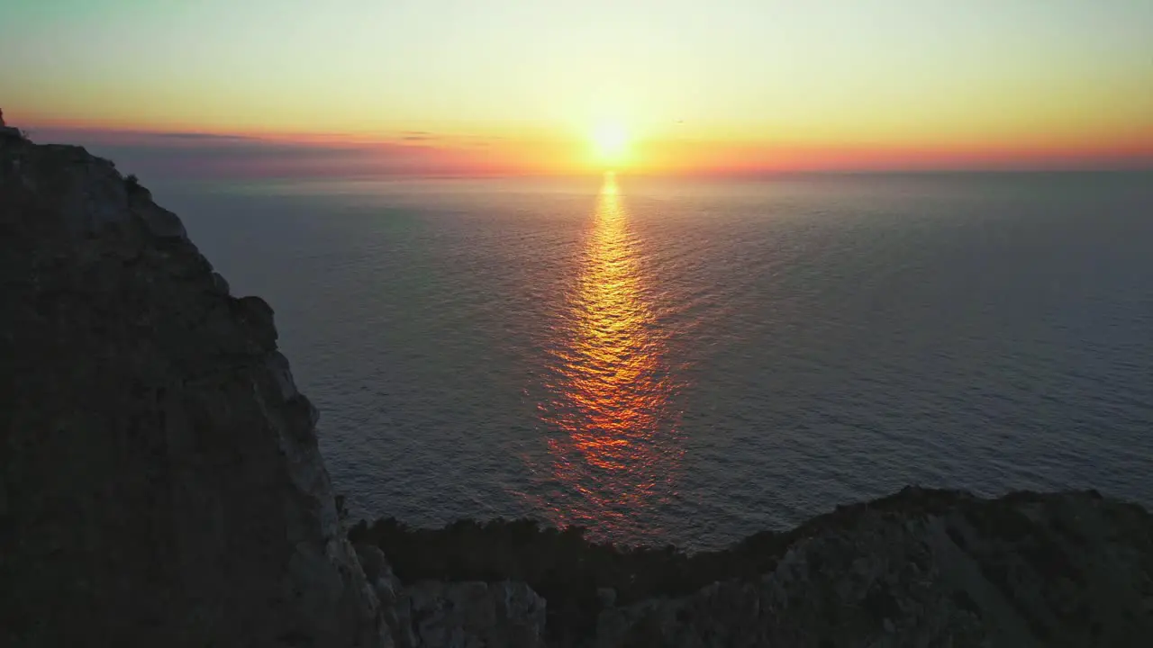 4k drone shot of sunset over ocean on coast of Ibiza in Balearic Islands