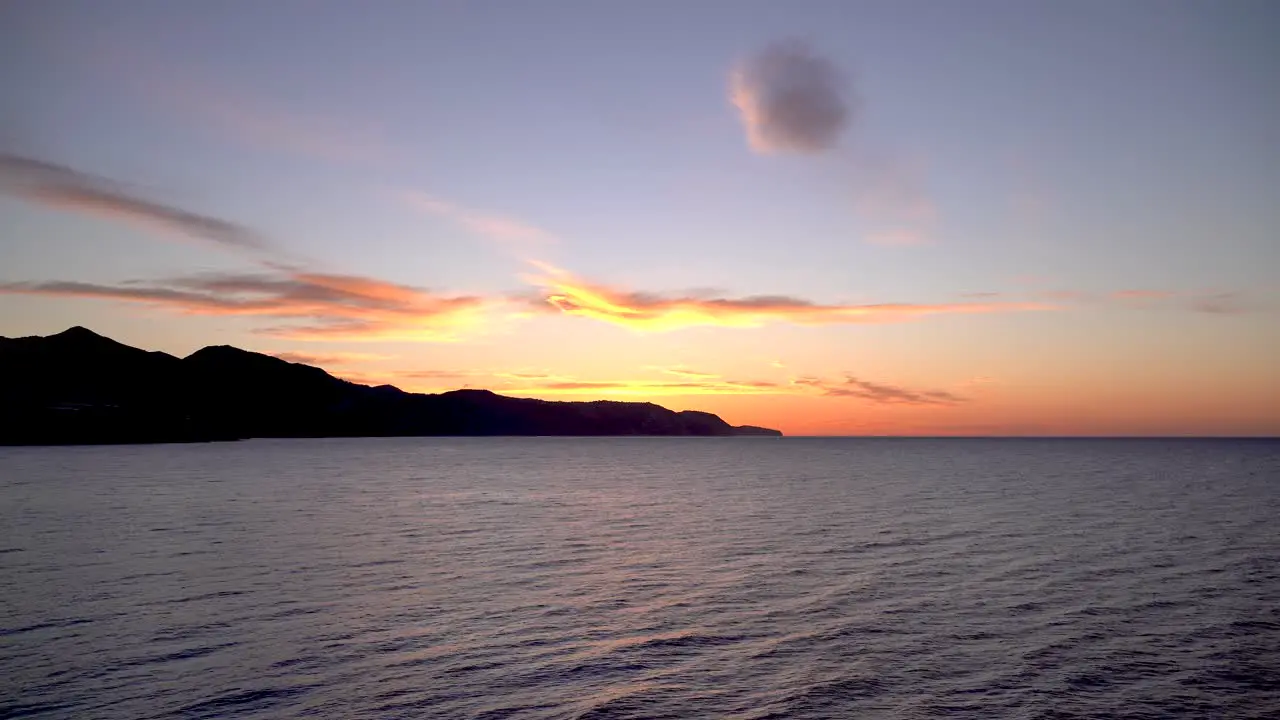 Breathtaking sunrise footage with mountain silhouettes at ocean