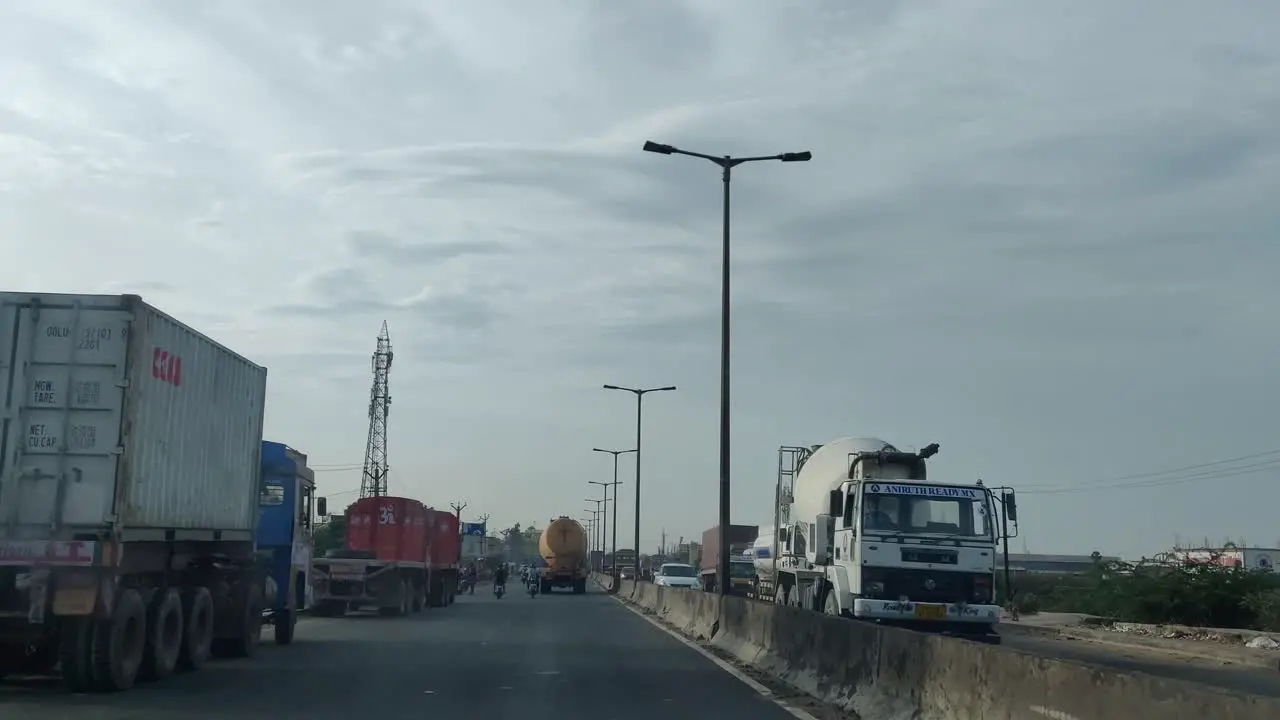 a view of highway road to minjur which has lorry and heavy duty vehicles parked on either side of roads