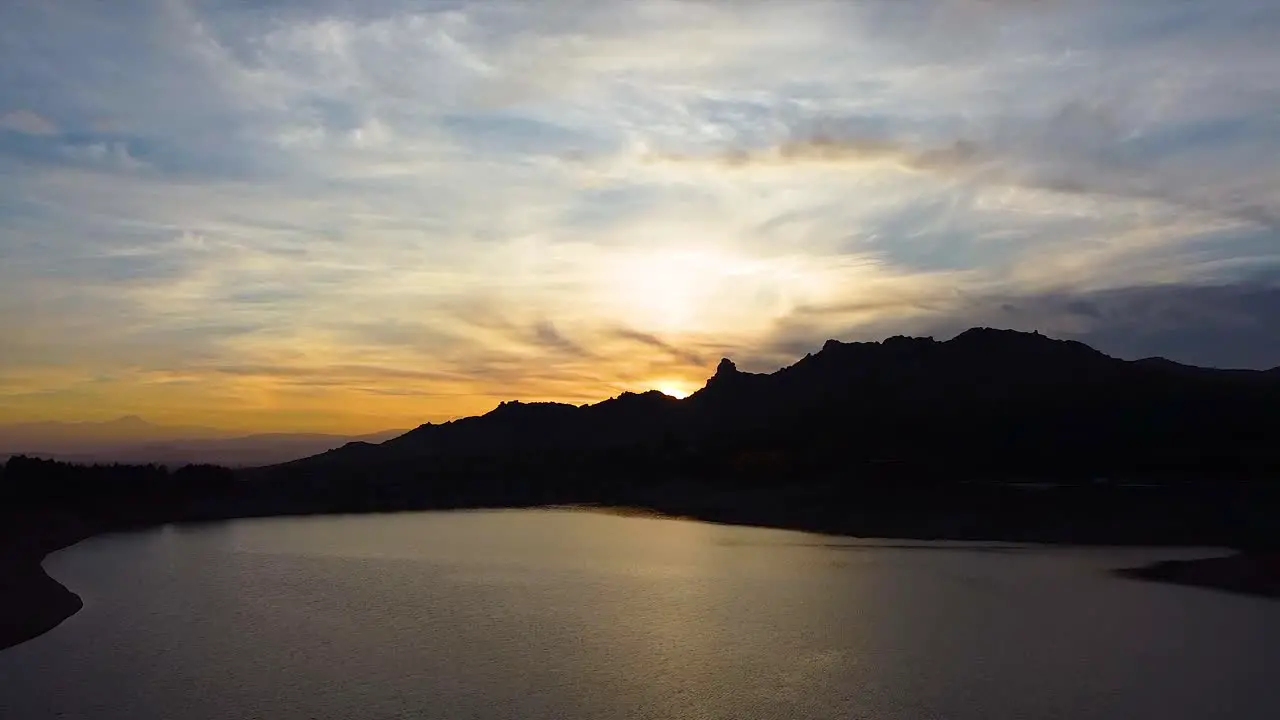 Aerial shot of a golden hour reflection on the surface of a natural lake