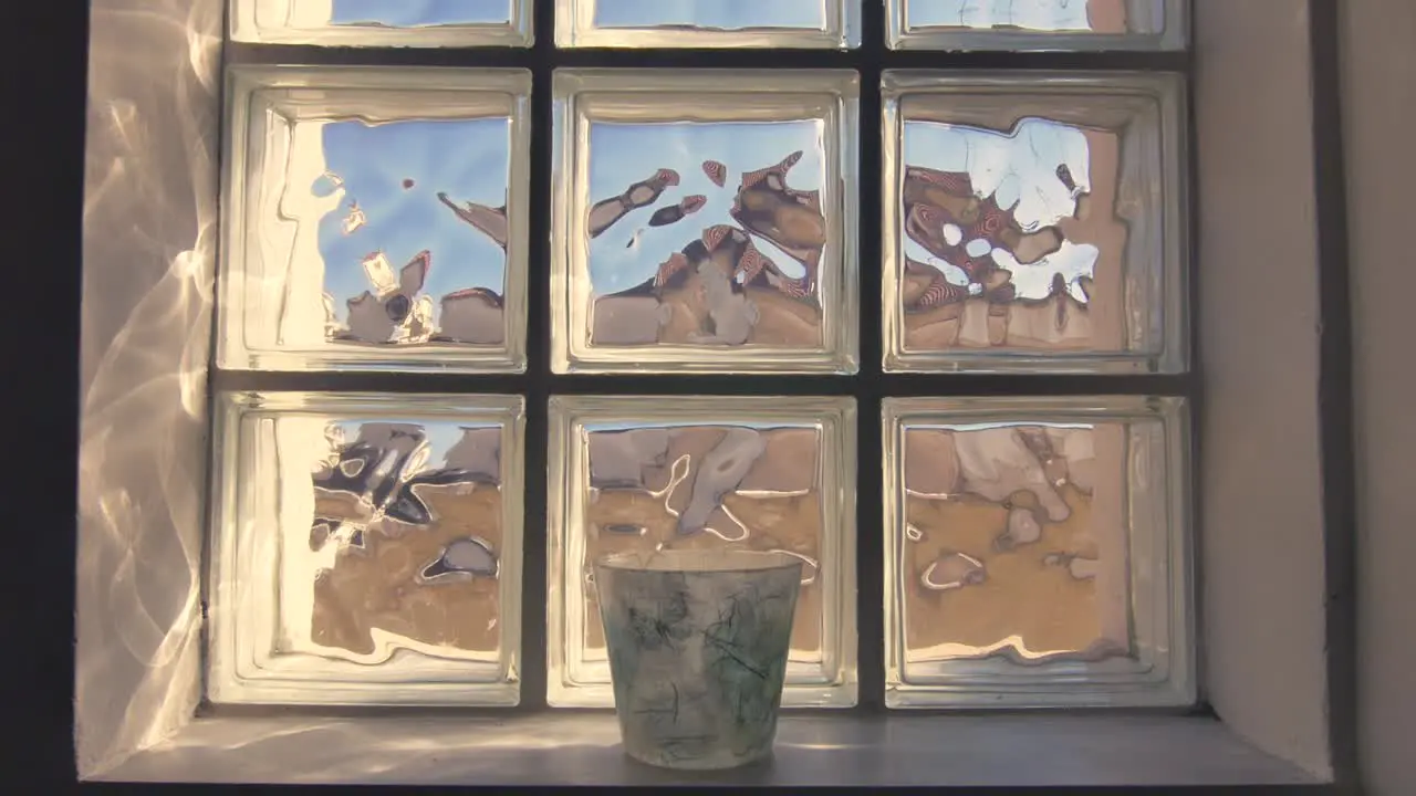 A slow approaching shot of a symmetrically framed window and pot