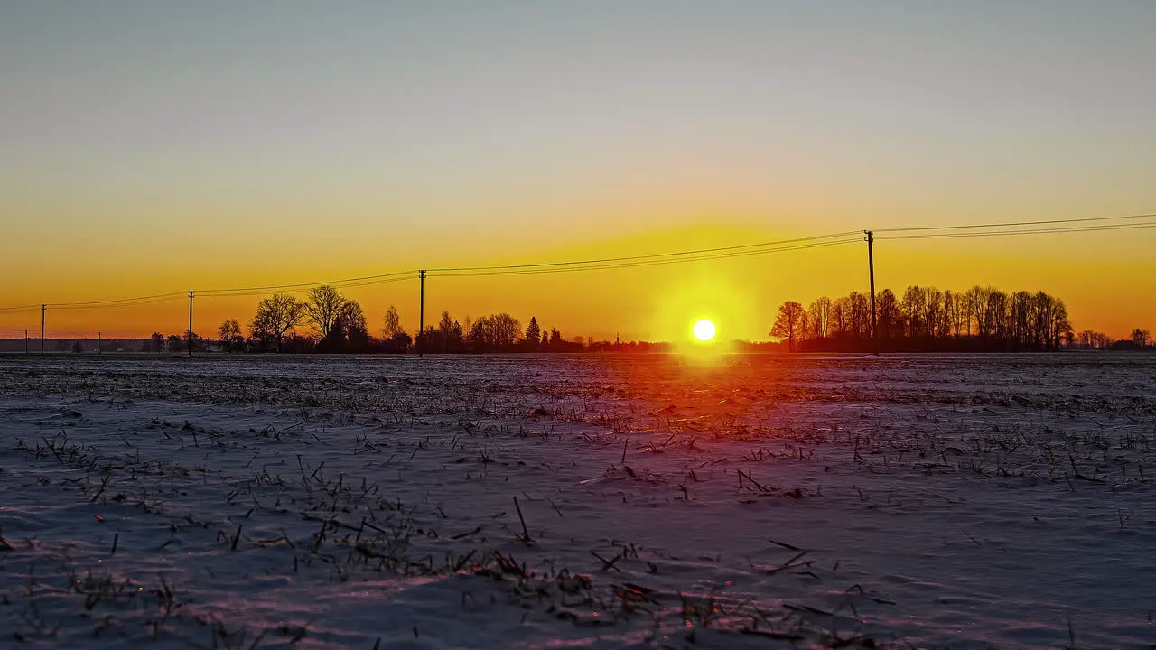 Picturesque golden sunrise at horizon on frozen winter morning time lapse