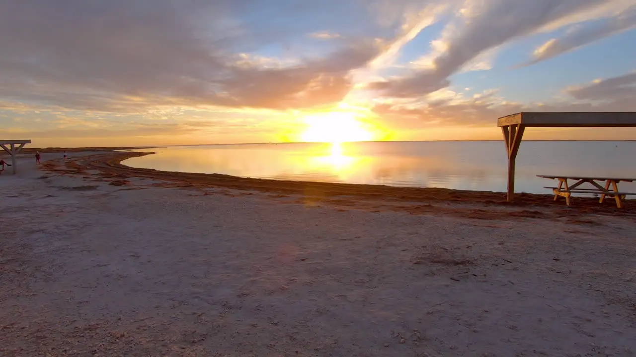 Time lapse of people beach and clouds at a splendid sunset over a tranquil Laguna Madres estuary