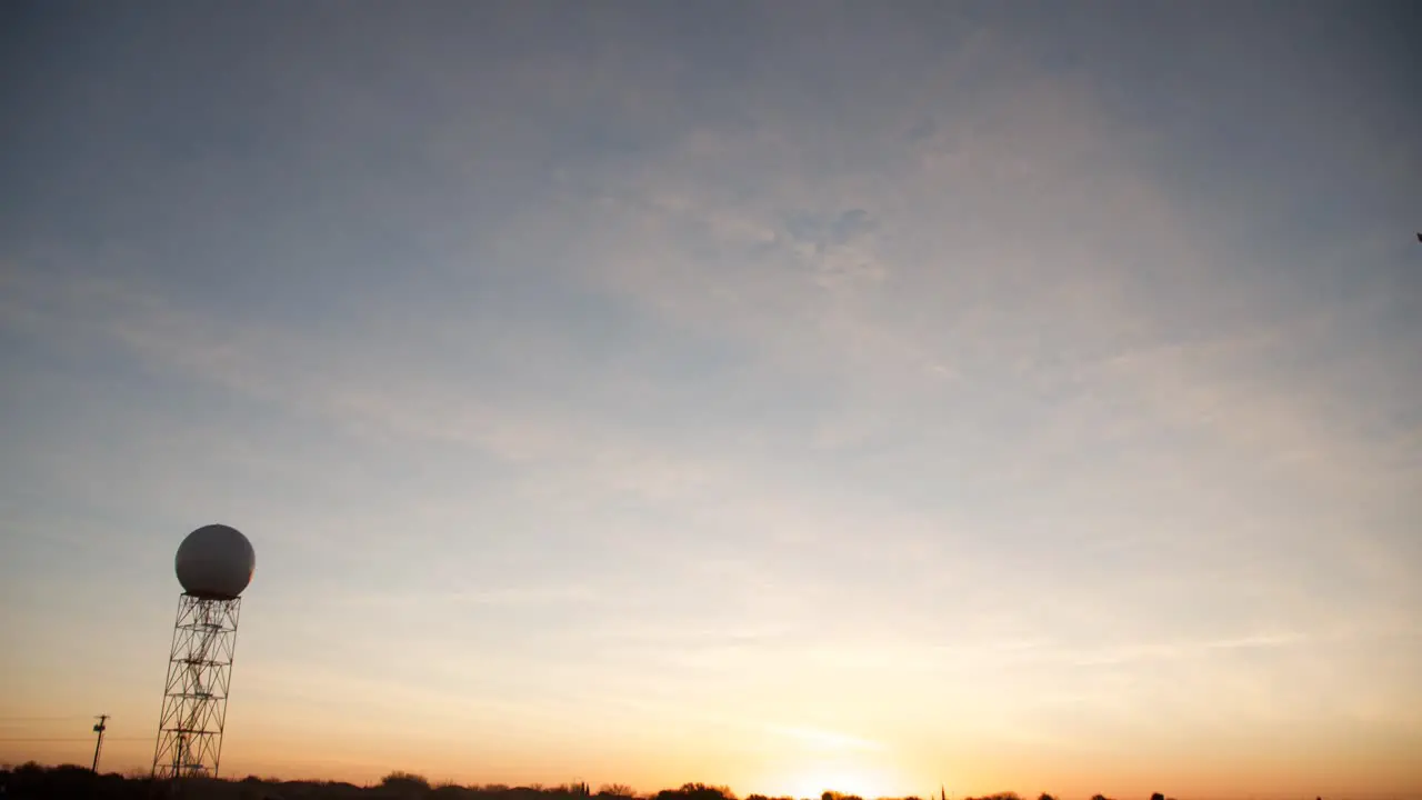 Sunrise hitting moving clouds behind the weather radar