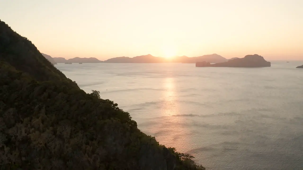 Aerial flying backwards showing island around El Nido with sunset Palawan Philippines