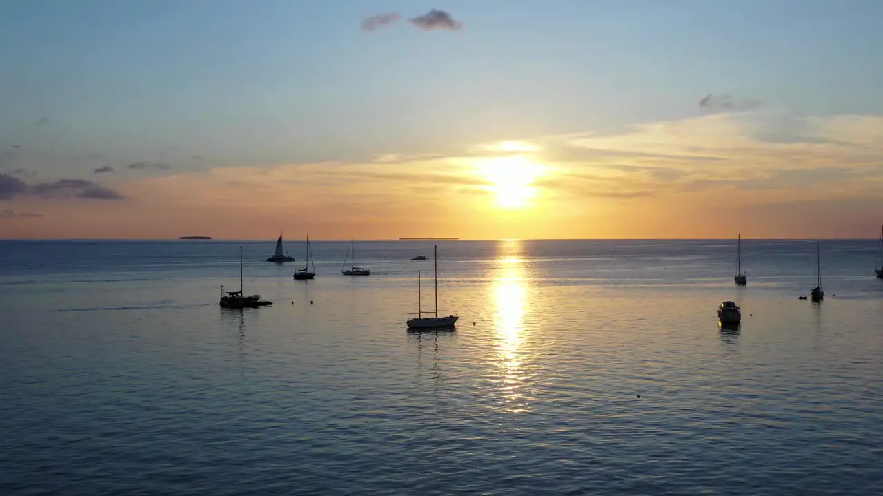 Calm sunset on the sea with some boats in the background and the horizon line