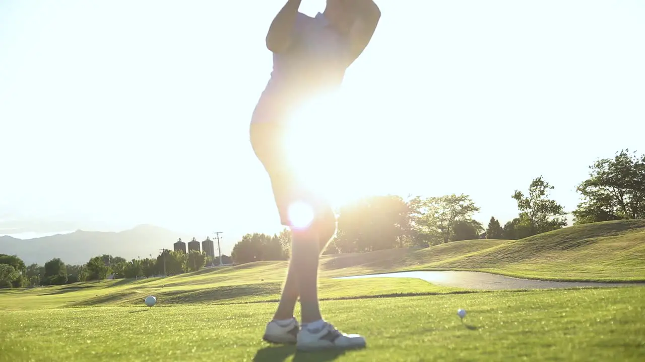 Slow motion shot of a male on a resort golf course about to drive a golf ball off of the teebox